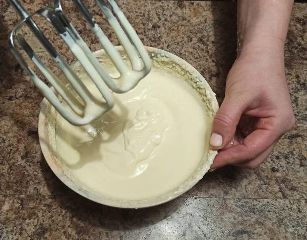 女人用奶油把搅拌器放在碗上 — 图库照片