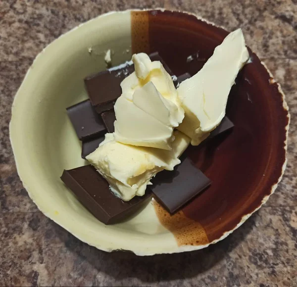 Tigela com manteiga e fatias de chocolate — Fotografia de Stock