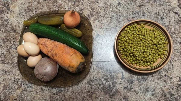 Ingredients for salad on plates on kitchen table — Stock Photo, Image