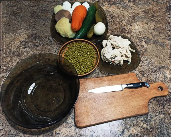 Ingredientes para ensalada y cubiertos en la mesa de la cocina —  Fotos de Stock