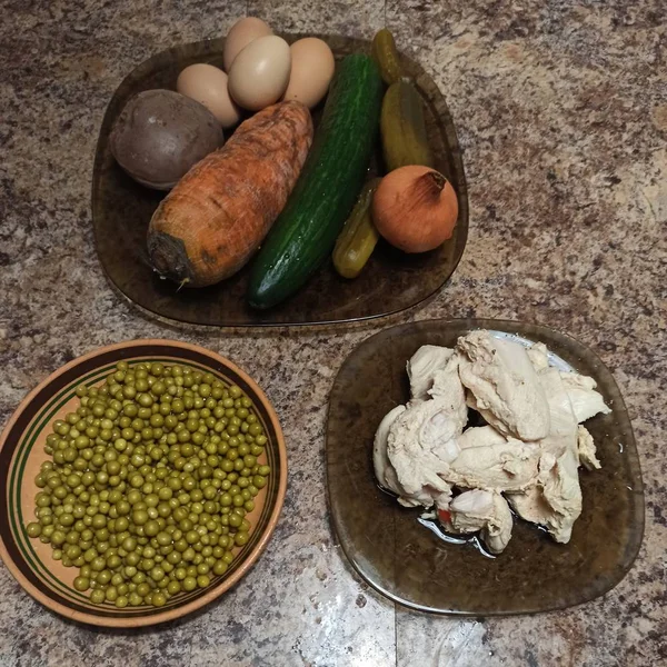 Ingredientes para ensalada en platos en la mesa de la cocina —  Fotos de Stock