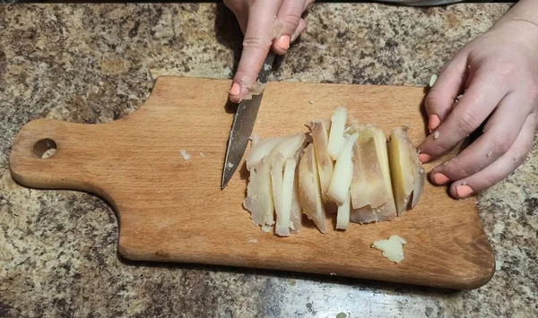 Mulher cozinheiro cortar batata na tábua de corte — Fotografia de Stock