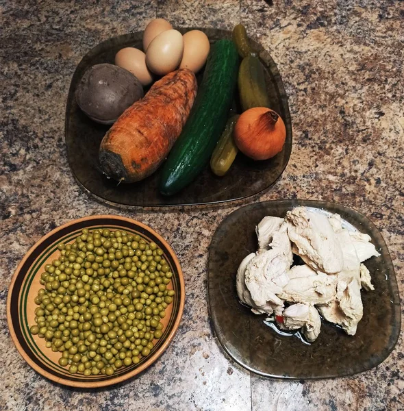 Ingredients for salad on plates on kitchen table — Stock Photo, Image