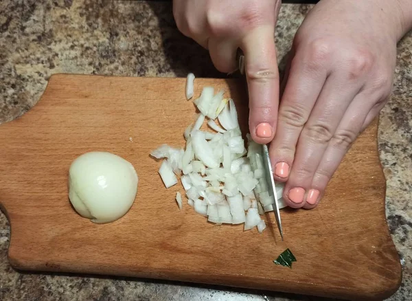 Kadın aşçı kesme tahtasında soğan kesiyor. — Stok fotoğraf