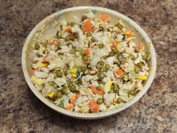 Tigela com salada russa na mesa da cozinha — Fotografia de Stock