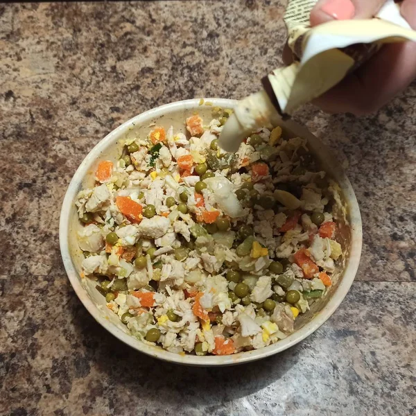 Mujer cocinar verter mayonesa al tazón con ensalada —  Fotos de Stock