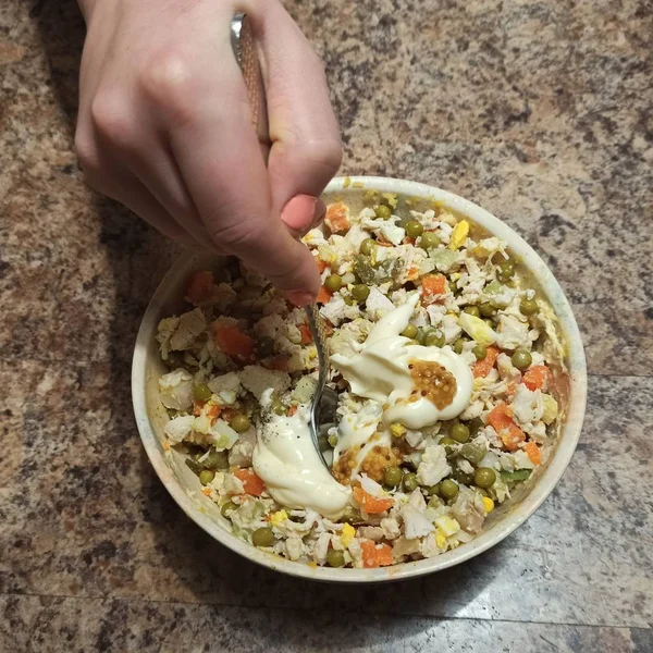 Mulher cozinheiro mistura salada russa na tigela — Fotografia de Stock