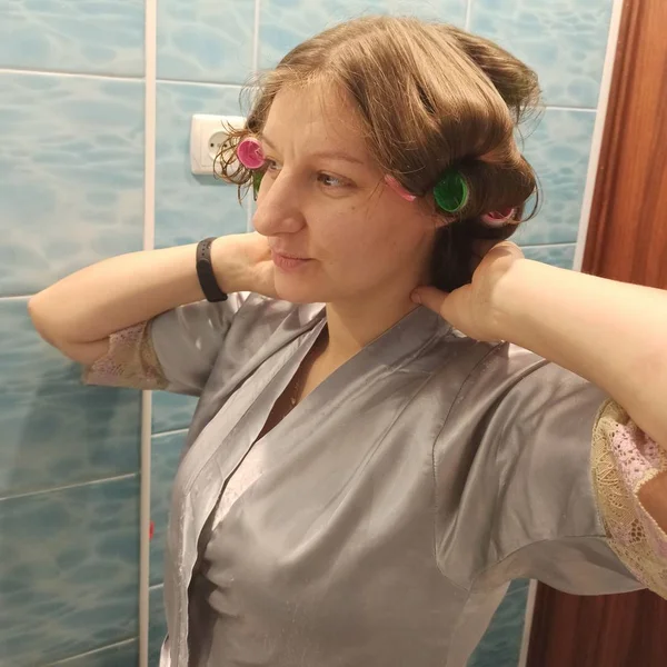 Mujer con rizadores en el pelo en el baño — Foto de Stock