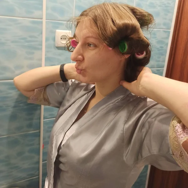 Mujer con rizadores en el pelo en el baño — Foto de Stock