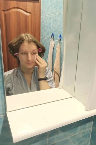 Europäerin wischt Haut im Badezimmer ab — Stockfoto