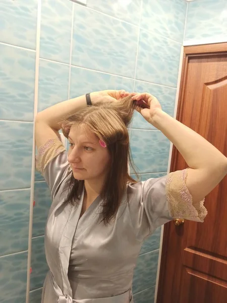 Европейская женщина наносит бигуди на волосы — стоковое фото
