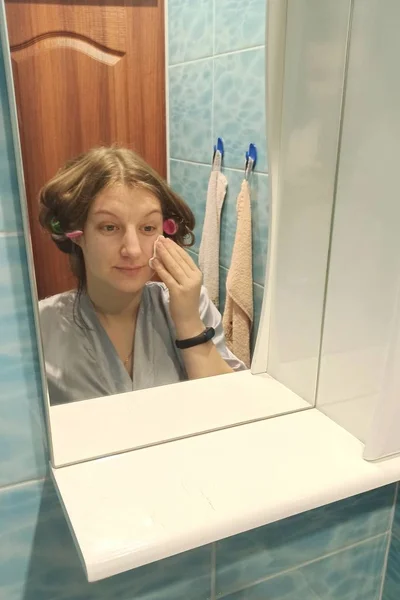 Europäerin wischt Haut im Badezimmer ab — Stockfoto
