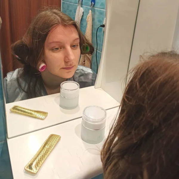 Europäerin sieht sich im Badezimmer im Spiegel an — Stockfoto