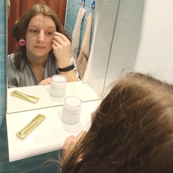 Mujer europea pinza las cejas en el baño — Foto de Stock