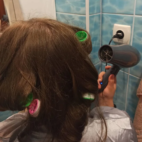 Woman dry hair with hairdryer at bathroom