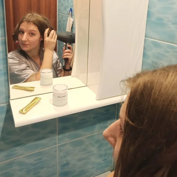 European woman dry hair with hairdryer at bathroom — 스톡 사진