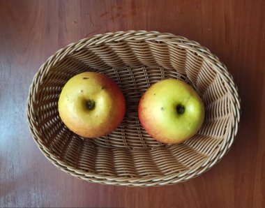 Tahta masadaki tahta sepetteki elmalar.