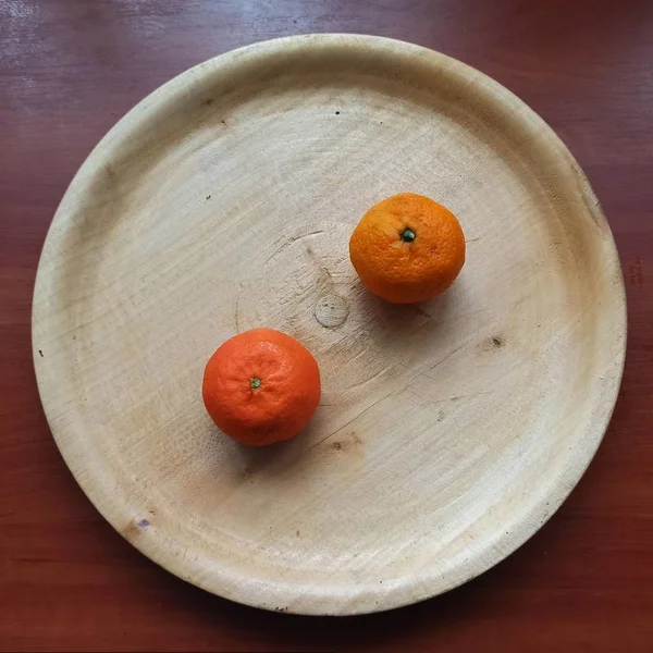 Mandarines on wooden tray on wooden table — Stock Photo, Image