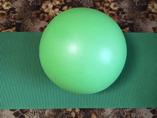 Fitness ball and fitness mat on carpet at home