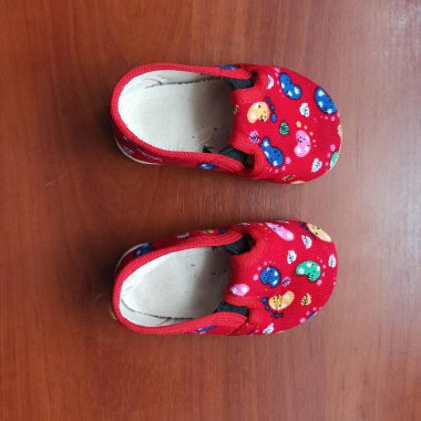 Childs slippers on wooden background