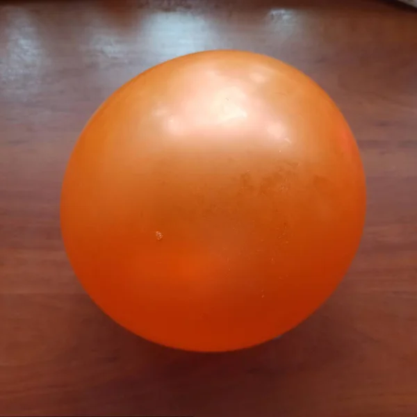 Orange balloon on wooden background — Stockfoto