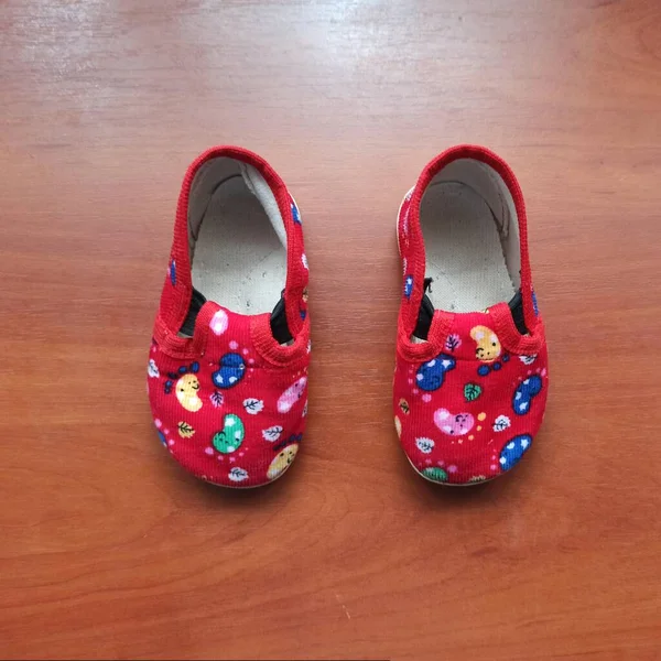 Childs slippers on wooden background — 스톡 사진