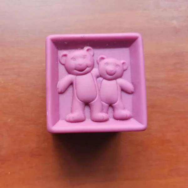Cubo de juguete púrpura con osos sobre fondo de madera — Foto de Stock