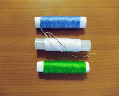 Dikiş ipliği ahşap arka plan üzerinde kümesi