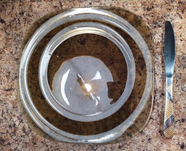 Plate with knife on kitchen table background