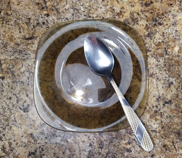 Тарелка с ложкой на кухонном столе — стоковое фото