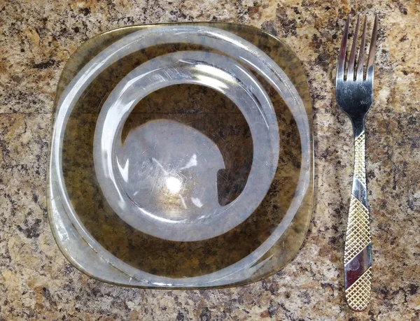 Talíř s vidličkou na pozadí kuchyňského stolu — Stock fotografie