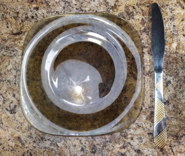 Teller mit Messer auf Küchentisch Hintergrund — Stockfoto