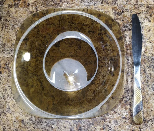 Πιάτο με μαχαίρι στο τραπέζι της κουζίνας φόντο — Φωτογραφία Αρχείου