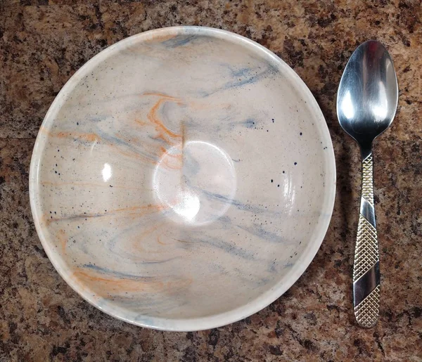 Miska z łyżką na tle stołu kuchennego — Zdjęcie stockowe