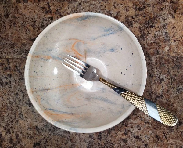 Miska z widelcem na tle stołu kuchennego — Zdjęcie stockowe