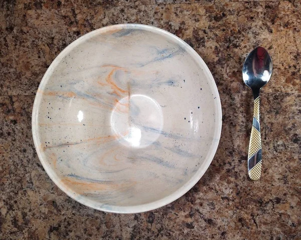 Miska z łyżeczką na tle stołu kuchennego — Zdjęcie stockowe