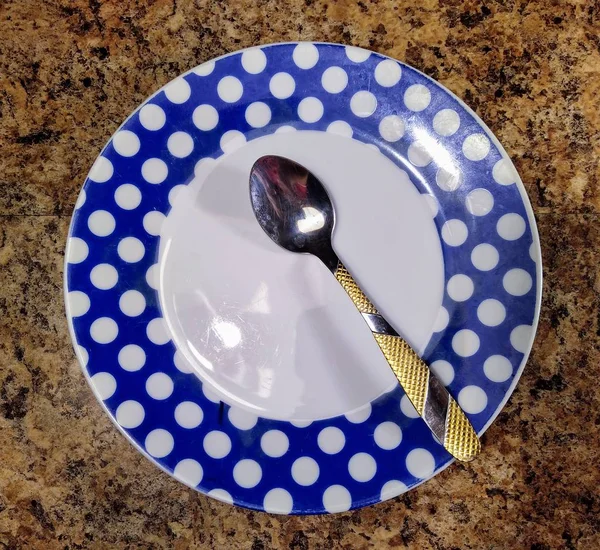 Placa com colher de chá no fundo da mesa da cozinha — Fotografia de Stock