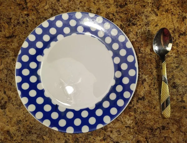 Plate with teaspoon on kitchen table background — Stockfoto