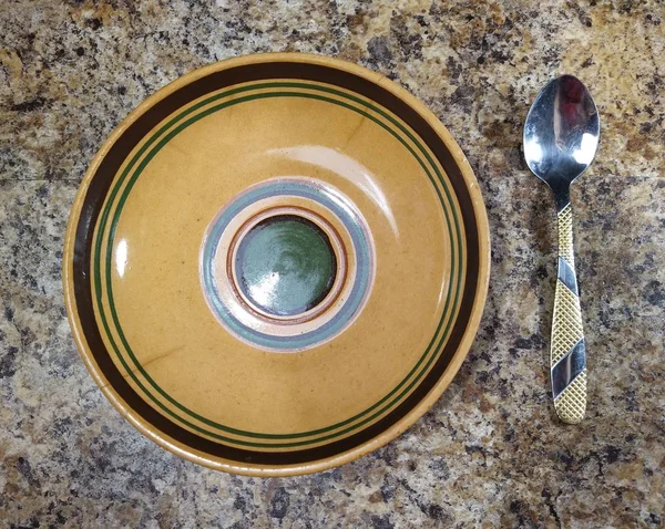 Тарілка з чайною ложкою на фоні кухонного столу — стокове фото