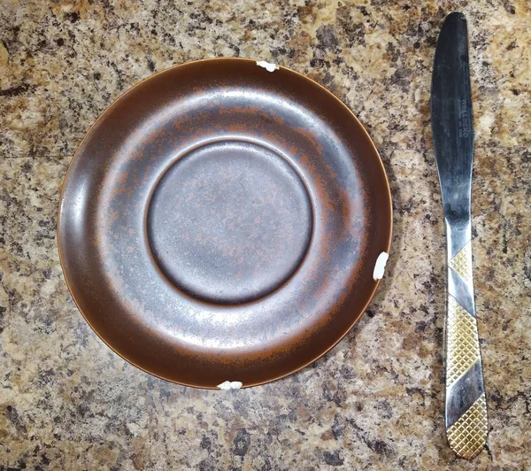 Placa con cuchillo sobre fondo de mesa de cocina — Foto de Stock