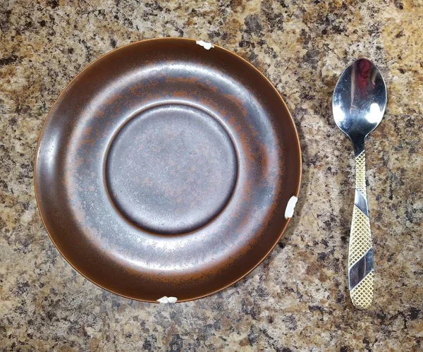 Teller mit Teelöffel auf Küchentisch Hintergrund — Stockfoto