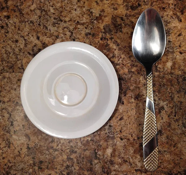 Πιάτο με κουτάλι στο τραπέζι της κουζίνας φόντο — Φωτογραφία Αρχείου