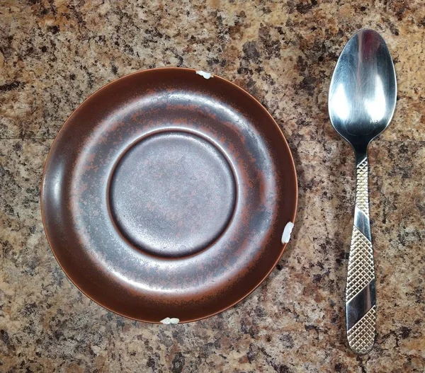 Assiette avec cuillère sur fond de table de cuisine — Photo