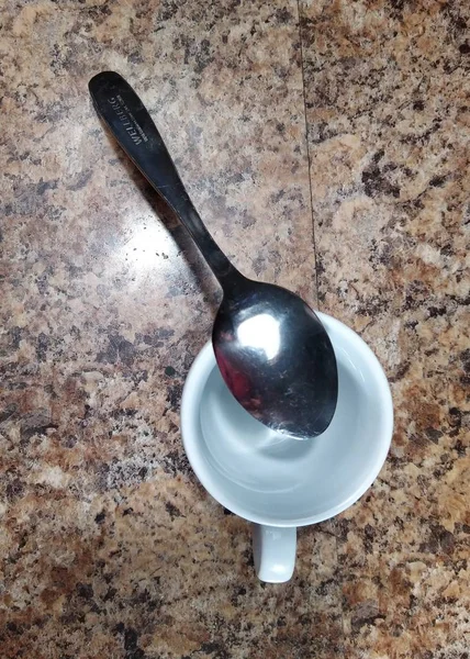 Taça com colher de chá no fundo da mesa da cozinha — Fotografia de Stock