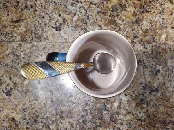 Taça com colher de chá no fundo da mesa da cozinha — Fotografia de Stock