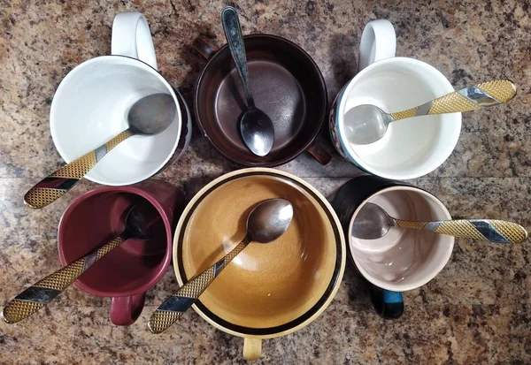 Sada šálků s čajovými lžičkami na kuchyňském stole — Stock fotografie