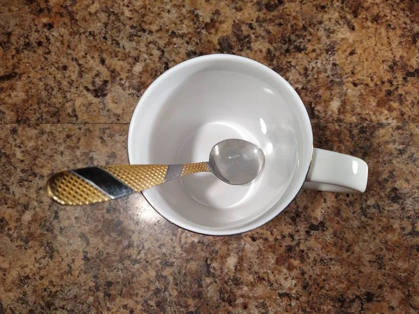 Tasse mit Teelöffel auf Küchentisch Hintergrund — Stockfoto