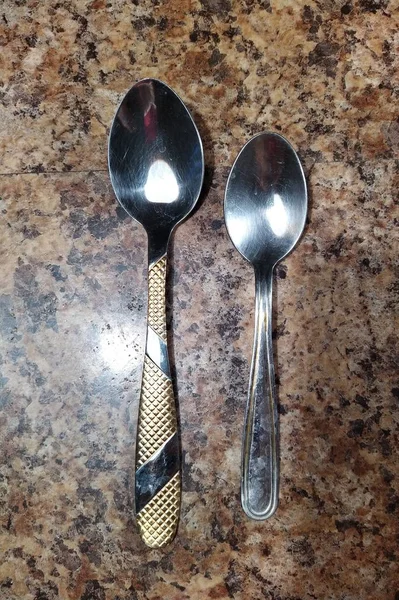 Spoon and teaspoon on kitchen table background