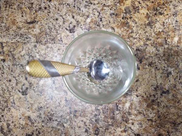 Verre avec cuillère à café sur fond de table de cuisine — Photo