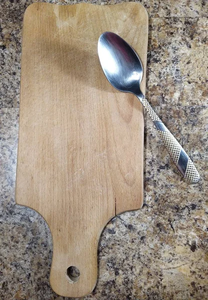 Tagliere con cucchiaio sul tavolo della cucina — Foto Stock